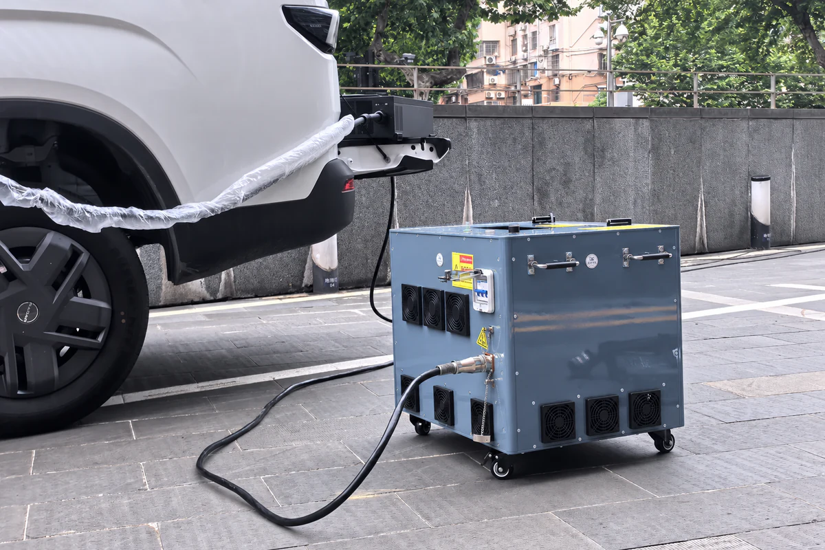 Station d’alimentation au sol reliée par câble à côté d’un véhicule