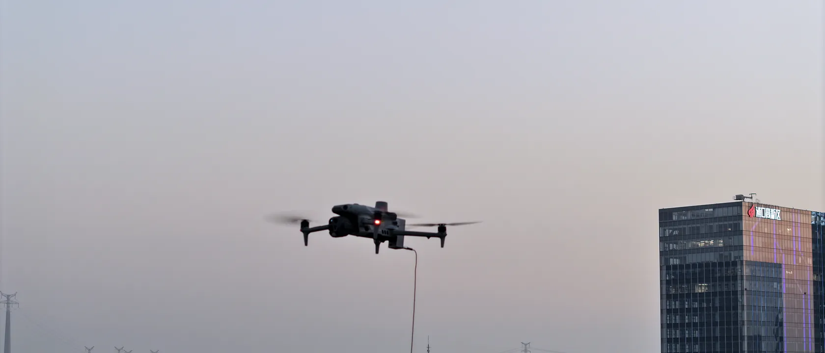 夕暮れに浮遊する小型の有線給電ドローン