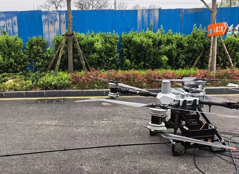 DJI FC100 industrial drone configured for tethered facade cleaning.
